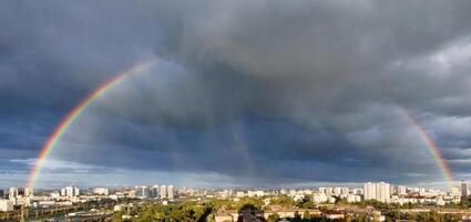 A large rainbow in the cloudy sky over the city after heavy rain. photo