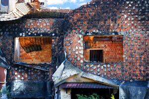 Window openings of a destroyed and burnt-out rural Ukrainian house after Russian aggression. photo