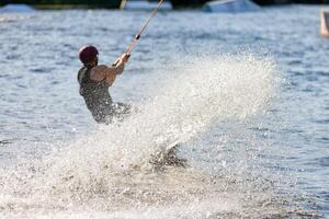 Splash of silver water splashes after a wakeboarder's sharp turn on the water surface of a river. photo