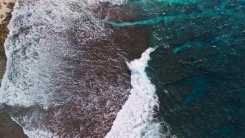 Crashing waves top view. Ocean waves above drone view video