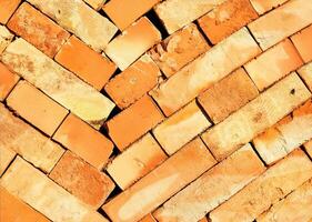 The texture of an orange stacked brick illuminated by the sun's rays. photo