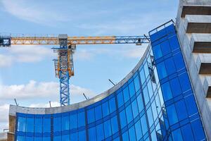 construcción de un Alto oficina edificio y fachada ventana revestimiento con azul vaso. foto