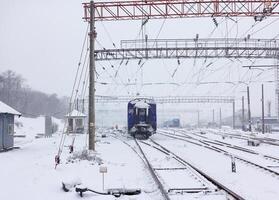 Railway train carriage resting on the tracks during snowfall on a winter day. photo