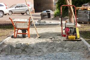 Laying paving slabs, necessary construction equipment at the workplace on a sunny summer day. photo
