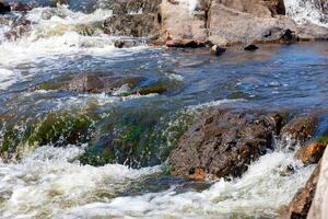 Fragment of stone thresholds in a turbulent stream of water of a mountain river. photo