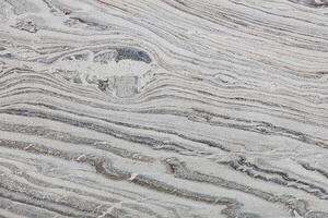 The texture of a stone polished surface with beautiful diagonal waves of relief pattern. photo