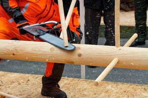 A lumberjack with a chainsaw at a competition to demonstrate professional use of the tool. photo
