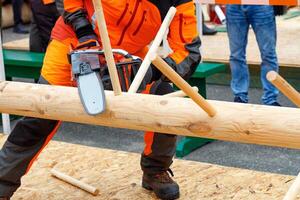 A fragment of the lumberjack competition, a demonstration of the technique of owning a chainsaw. photo