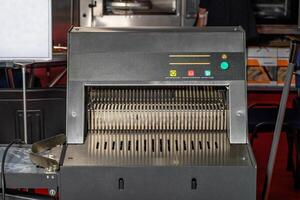 Industrial bread slicing machine for slicing bread into thin symmetrical slices. photo