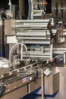 Fragment of an automatic packaging line with roller guides at a food factory. photo
