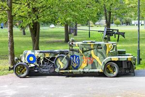 The armored car is stylized as an antique car, painted in camouflage colors with the coat of arms of Ukraine. 05.09.2023. Kyiv, Ukraine. photo