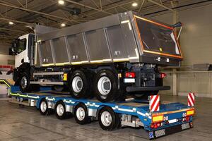 Large dump truck loaded on low loader platform trailer for transportation. photo