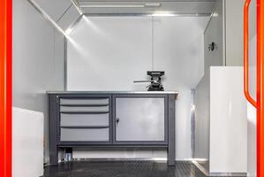 Interior of a modern truck-based mobile workshop with a gray workbench, elegant design, practical workspace concept. photo