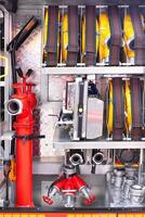 Firefighting equipment organized inside fire truck compartment with hoses, nozzles, tools, showcasing emergency readiness concept photo