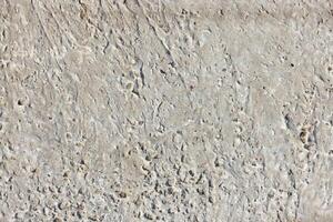 Concrete texture with small holes and irregular surface, perfect for backgrounds and design projects, construction material concept photo