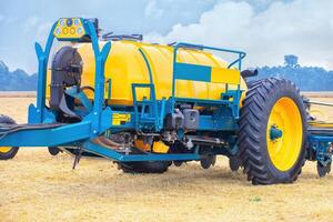 Modern agricultural machinery in field, yellow tractor with large wheels, advanced technology, farming vehicle concept photo