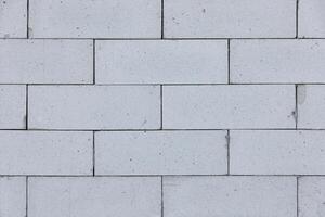 Sturdy white bricks form an intricate wall pattern in natural light at midday, showcasing texture photo