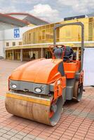 Heavy machinery smoothing pavement at a construction site near an architectural landmark photo