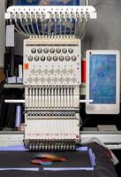 Intricate embroidery machine in action creating colorful designs in a workshop setting photo
