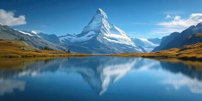 Matterhorn reflecting in stellisee lake on a sunny day with clouds and blue sky photo