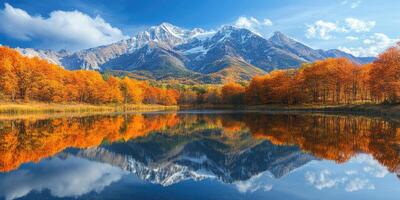 Snow capped mountain reflecting in lake with autumn trees photo