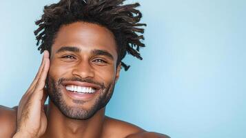 Bright smile of man with curly hair against blue background photo