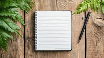 simple workspace with notebook and pen surrounded by greenery photo