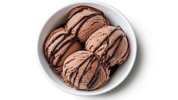 Rich chocolate ice cream scoops drizzled with chocolate sauce in bowl photo