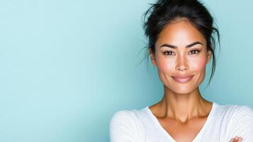 Confident Asian woman smiling with arms crossed against blue background photo