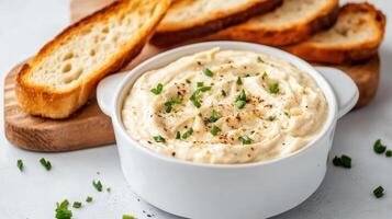 Creamy garlic dip served with toasted bread slices, perfect for sharing photo