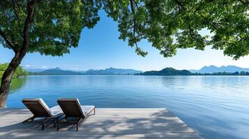 serene lakeside view with lounge chairs under lush trees photo