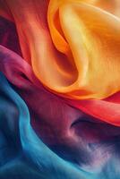 Vibrant silk fabric draped in waves of orange, yellow, red, and blue photo