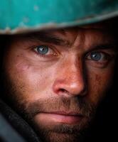 Miner with piercing blue eyes focusing on his work in a dark environment photo