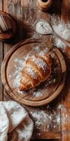 Freshly baked croissant on wooden board sprinkled with flour photo