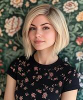 Young woman poses with floral background while wearing a black top photo