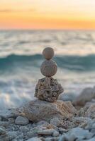 Balancing stones create a serene sculpture at sunset by the ocean photo