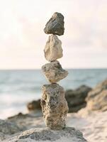 Balancing rocks on beach shore at sunset creates serene atmosphere photo