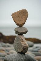 Balanced stones stacked on a rocky shore near the water's edge photo