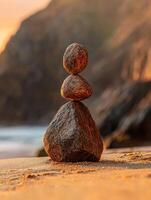 Peaceful stone balancing at sunset on a serene sandy beach photo