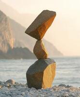 Balanced stones at the shore during sunset create a serene landscape photo