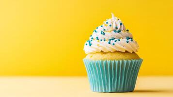 Colorful Cupcake with Creamy Frosting and Sprinkles on a Bright Yellow Background photo