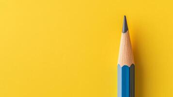 Sharpened Yellow Pencil on Vibrant Yellow Background with Copy Space photo