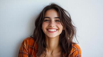 Cheerful Young Woman Smiling Casually Against Plain Wall photo