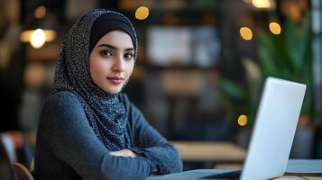 Confident and Ambitious Muslim Female Entrepreneur Empowered in Digital Technology and Engineering,Sitting at Desk with Laptop and Working on Project photo