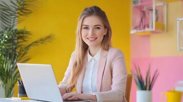 Portrait of a young,stylish Caucasian female manager sitting at her desk and using a laptop computer in a modern,contemporary marketing agency office setting. She appears focused,productive. photo