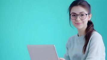 Portrait of a young,confident female wearing glasses and using a laptop computer,showcasing her expertise as an information technology specialist or software engineer. photo