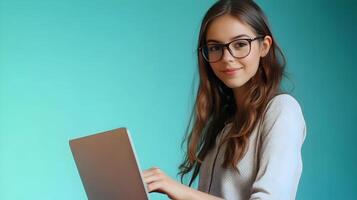 Confident and focused young female professional wearing eyeglasses while using a laptop computer at her desk in a modern office setting. photo