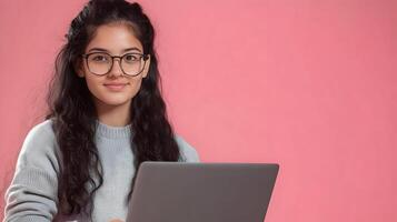 Portrait of a confident and focused young woman wearing glasses and using a laptop computer,representing an information technology specialist,software engineer. photo