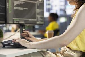 Programmer typing on computer keyboard, conducting tests to optimize machine learning models for performance and accuracy. Close up of IT professional in office analyzing data photo