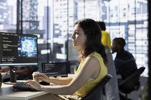 Data scientist utilizing cloud computing resources and platforms to train and deploy large scale machine learning models. Woman in business office monitoring and maintaining company systems photo